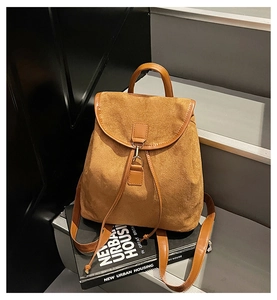 Vue détaillée du sac à dos en daim marron avec fermeture à cordon et boucle en métal