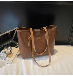 Detail of vintage brown leather tote bag with gold lettering and spacious interior