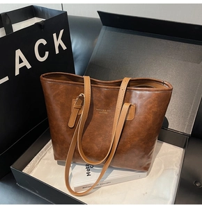 Detail of vintage brown tote bag with gold lettering in premium gift box setting