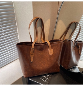 Detail of dark brown leather tote bag showing fine texture and adjustable strap