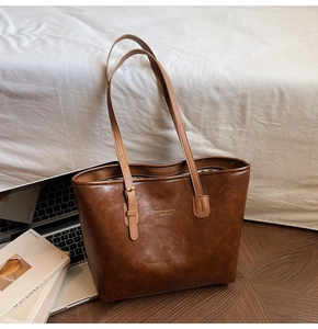 Detailed shot of dark brown retro tote bag with golden lettering and adjustable straps