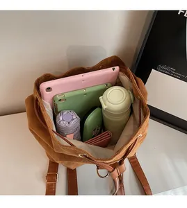 Détail de l'intérieur spacieux d'un sac à dos en daim marron avec cordon de serrage