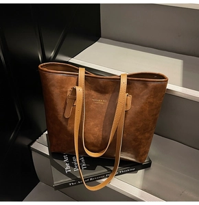Close-up of vintage brown tote bag with leather texture on black and white stairs
