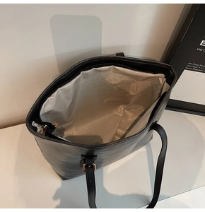 Top view of black leather tote bag showing spacious interior with herringbone lining