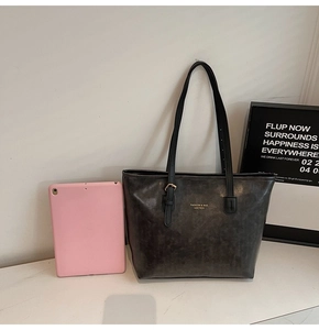 Detail of dark grey tote bag showing large capacity for a tablet and adjustable straps