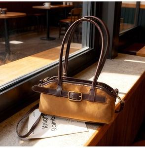 Détail d'un sac porté épaule en daim marron avec boucle en métal doré élégant