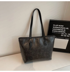 Detailed macro view of dark grey tote bag showing vintage texture and long shoulder strap