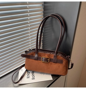 Détail du sac bandoulière en daim marron avec sangle en cuir poli et boucle dorée chic