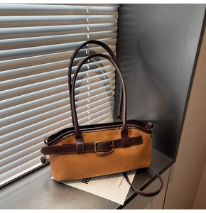 Détail du sac à main en daim avec lanière en cuir marron et boucle carrée dorée