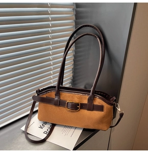 Détail du sac bandoulière en daim marron avec lanières en cuir et boucle dorée