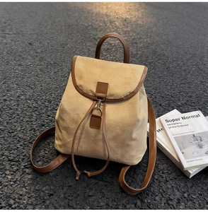 Gros plan détaillé d'un sac à dos en daim beige sable avec garniture en cuir marron