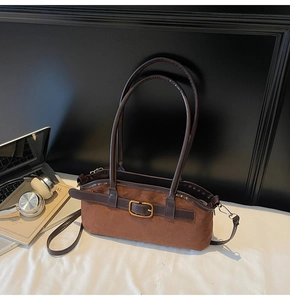 Détail macro du sac hobo en daim caramel avec boucle dorée vintage et fines lanières