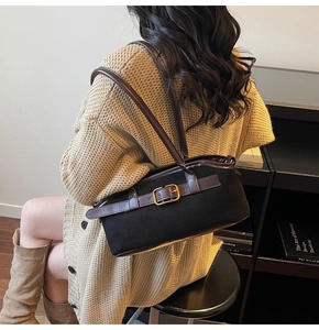 Détail d'un sac à bandoulière vintage avec lanières brunes et boucles en métal doré