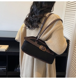 Détail du sac bandoulière vintage en daim noir avec sangle en cuir et boucle dorée