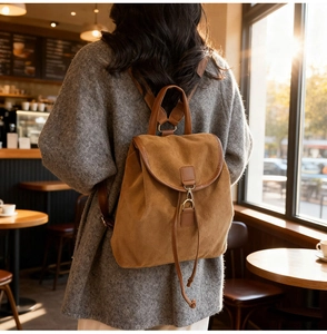 Gros plan d'un sac à dos vintage en daim marron avec finitions en cuir dans un café