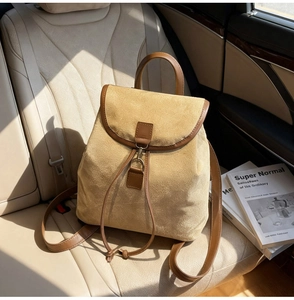 Détail du sac à dos en daim avec garniture en cuir sur siège auto au soleil doux