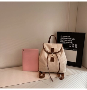 Détail d'un sac à dos vintage en toile avec garniture en cuir marron et boucle sur une table