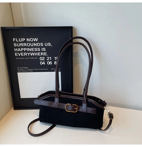 Détail d'un sac vintage noir mat avec bordures en cuir marron et boucle dorée élégante