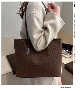 Fashionable leopard print tote bag styled with a white coat in a bright studio