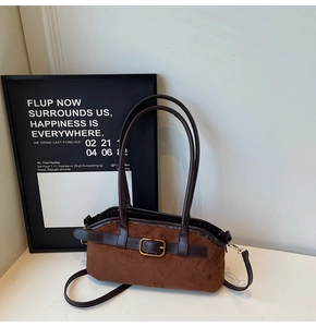 Détail du sac bandoulière en daim marron avec lanières en cuir et boucles dorées chic