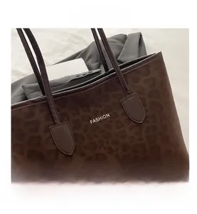 Close-up of leopard print tote bag with FASHION lettering and slim shoulder strap