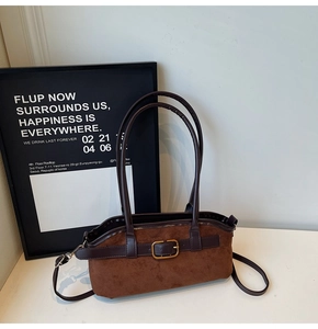 Gros plan du sac hobo en daim marron vintage avec bandoulière cuir et boucle dorée chic