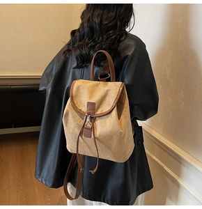 Vue détaillée d'un sac à dos en daim kaki avec des lanières en cuir marron sur un modèle
