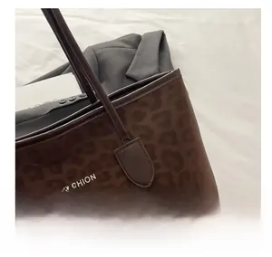 Close-up of leopard print tote bag detailing with leather handle and FASHION lettering