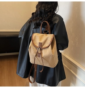 Vue détaillée du sac à dos en daim kaki avec garniture en cuir brun et cordon