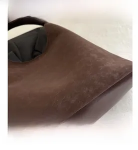 Dettaglio della borsa tote marrone scuro con trama scamosciata e scritta FASHION