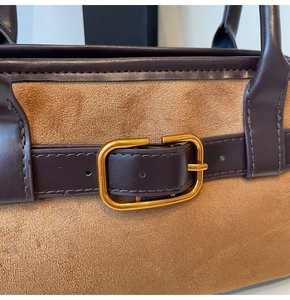 Détail du sac bandoulière en daim fauve avec brides en cuir et boucle en métal doré