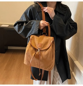 Détail du sac à dos vintage en daim marron avec boucle métallique et cordon de serrage