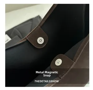 Dettaglio della chiusura magnetica in argento sulla borsa tote vintage in pelle