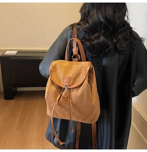Vue arrière d'un mannequin portant un sac à dos en daim marron avec cordon et rabat épuré