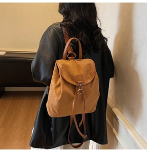 Caramel frosted leather backpack with flap closure and metal lock detail on model