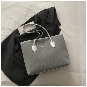Détail du cabas léopard gris avec bandoulières argentées et inscription tendance