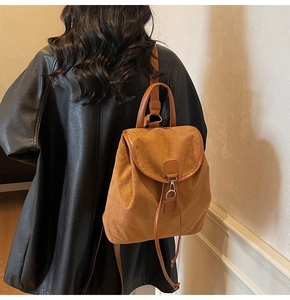 Vue arrière du mannequin portant un sac à dos vintage en daim marron avec boucles en métal