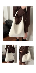 Détail d'un sac cabas blanc minimaliste montrant la finition en cuir mat et le logo de mode