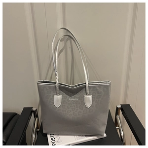 Detail van de zilveren shopper met luipaardprint, matte textuur en FASHION-belettering