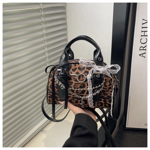 Dettaglio borsa leopardata con fiocco di seta, pizzo e catene metalliche argentate