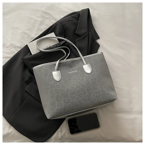 Détail du cabas imprimé léopard gris avec anses argentées et texte Fashion blanc