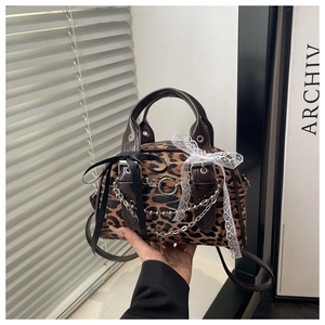 Close-up of leopard print bag with lace bows, velvet texture and metallic chain details