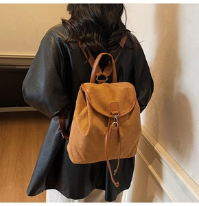 Détail d'un sac à dos en daim marron avec boucle métallique et fermeture à cordon