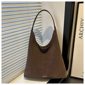 Dettaglio della borsa tote in pelle marrone scuro con scritta FASHION in stile minimalista