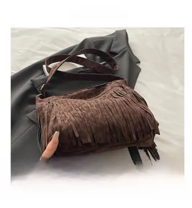 Detailed close-up of brown suede tote bag with fringe tassels and leopard print strap