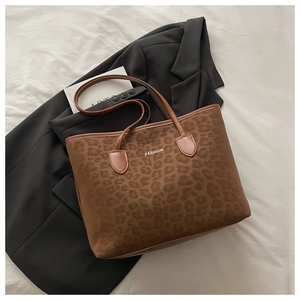 Détail du sac cabas léopard avec texte FASHION blanc et anses en cuir marron