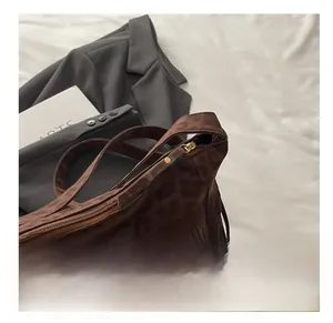 Detail view of smooth zipper closure on brown leopard print tote bag with stylish fringes