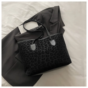 Gros plan sur la texture léopard d'un sac cabas noir avec finitions en daim élégant