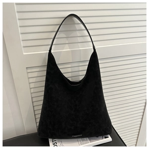 Dettaglio della grande borsa hobo nera con scritta fashion e trama scamosciata opaca