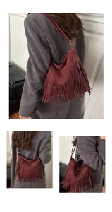 Detail of burgundy fringe hobo bag with tiered long tassels and elegant shoulder strap